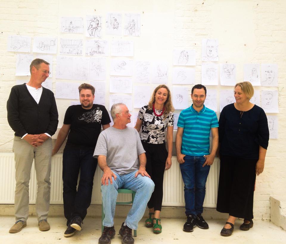 Plínio com seus alunos adultos em Frankfurt, os desenhos deles na parede atrás